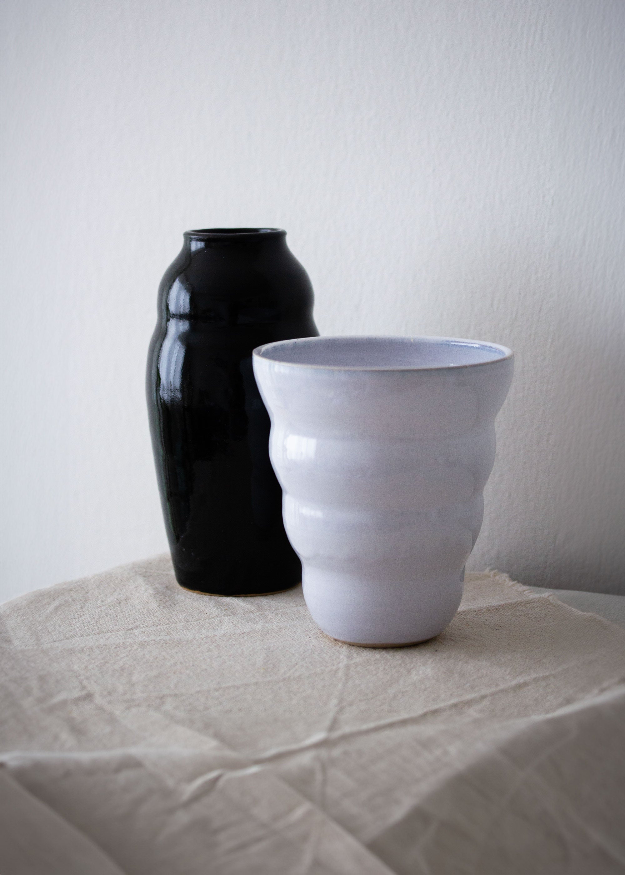 Eine schwarze und eine weiße Vase nebeneinander